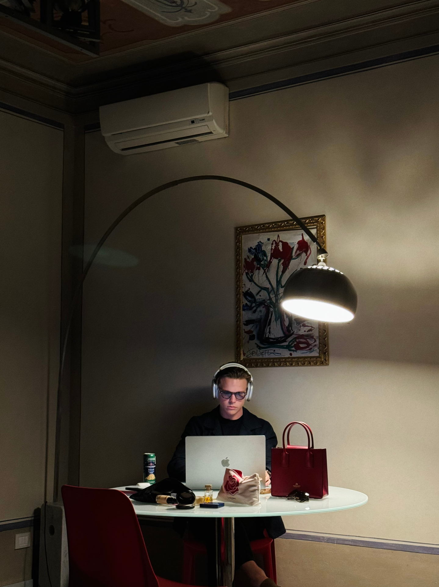 Late-night work session with laptop and headphones under a lamp